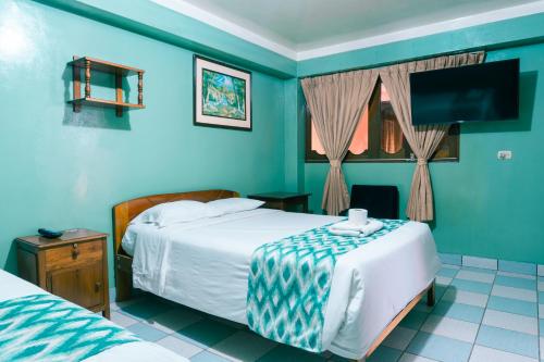チャチャポヤスにあるALPA KASA CHACHAPOYASの青いベッドルーム(ベッド2台、テレビ付)