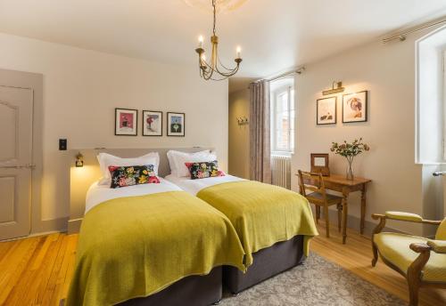 - une chambre avec 2 lits et des couvertures jaunes dans l'établissement The Manoir, à Morzine