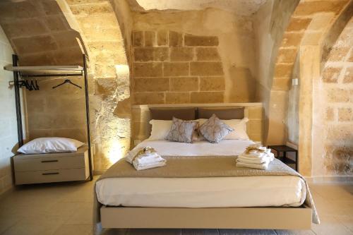 een slaapkamer met een bed met handdoeken erop bij Suite San Placido in Matera