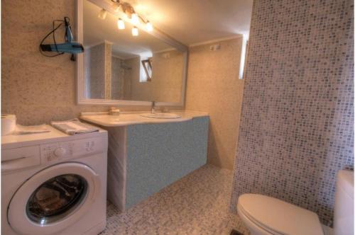 a bathroom with a washing machine and a sink at Stone Villa I in Petres in Petres