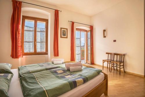 1 dormitorio con 1 cama y 2 ventanas en Residence Lena App 1 with Balcony, en Tenno