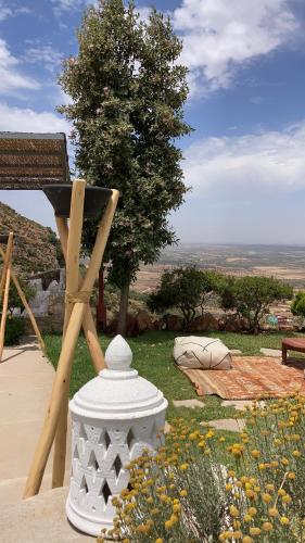 a white statue sitting in a field of flowers at Dar El Mandar - Ferme & Table d'Hôte Berbère in Bhalil
