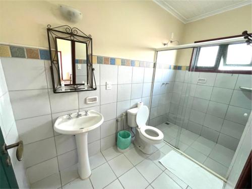 a bathroom with a sink and a toilet and a mirror at Pousada do Duque in Lambari