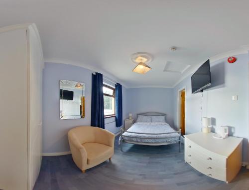 斯特拉班的住宿－The Coach Inn，一间卧室配有一张床、一把椅子和电视。