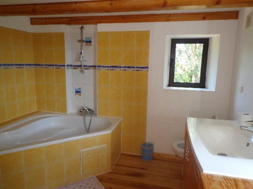 a bathroom with a tub and a sink at Les gîtes de Franck in Fayssac