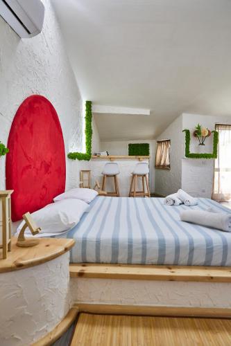 a bedroom with a large bed and two stools at REnt room Japaroom in Anguillara Sabazia