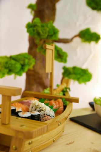 a wooden basket filled with sushi and vegetables on a table at REnt room Japaroom in Anguillara Sabazia