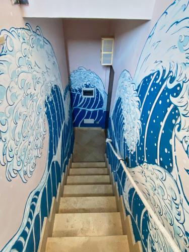 a staircase with blue and white waves painted on the wall at REnt room Japaroom in Anguillara Sabazia