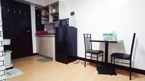 a small kitchen with a table and a black refrigerator at Relaxing 1-Bedroom Condo Unit (by Lee Portum) in Marilao