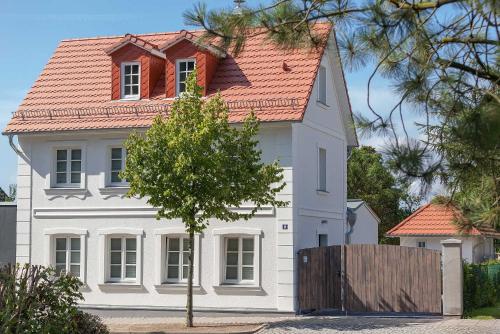 une grande maison blanche avec un toit rouge dans l'établissement Ferienhaus Idyll, à Putbus