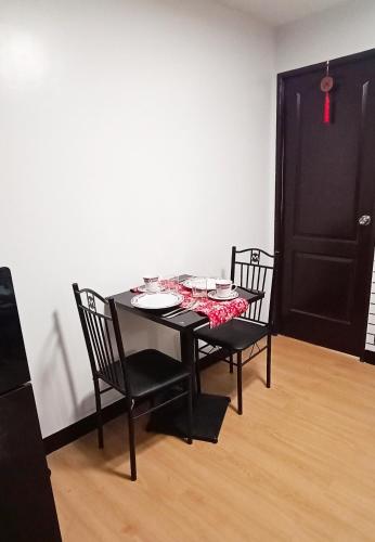 a black table with two chairs and a black door at Relaxing 1-Bedroom Condo Unit (by Lee Portum) in Marilao
