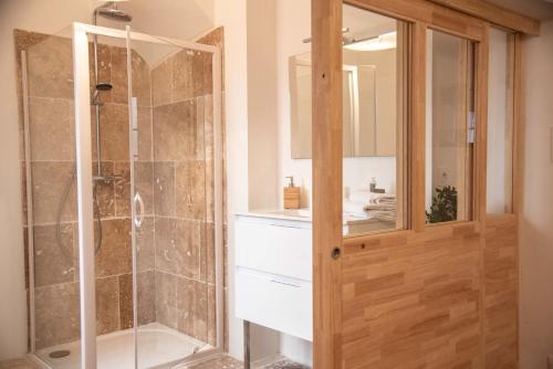 une salle de bain avec une douche avec une porte vitrée dans l'établissement Le PETIT AVIGNONNAIS - SUAVECORAZON - INTRAMUROS - CENTER, à Avignon
