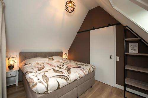 um quarto com uma cama grande num sótão em 't sfeeruus em Serooskerke