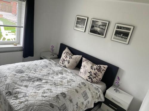 1 dormitorio con 1 cama y cuadros en la pared en Familie Decker-Behrends en Upleward