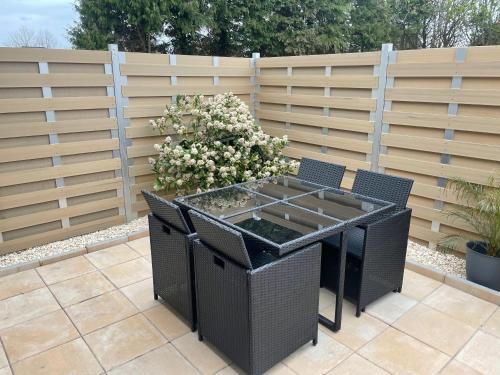 a patio with a table and chairs and a fence at Familie Decker-Behrends in Upleward