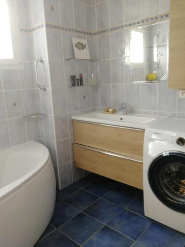 une salle de bain avec un lavabo et une machine à laver dans l'établissement Bel appartement calme et proche des plages, à Hyères