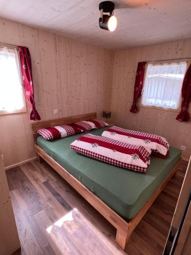a bedroom with two beds in a room at Bungalow Li Presi in Camping Cavresc, Via dal Cavresc 1, 7746 Le Prese-Poschiavo in Poschiavo