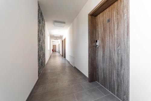 a hallway with a wooden door and a tile floor at Penzion Kurtovka Staňkovice in Staňkovice