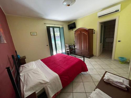 a bedroom with a bed with a red blanket at Pietrabianca Country House in Manocalzati
