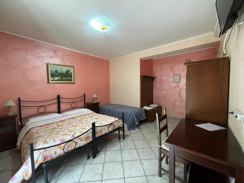 a bedroom with a bed and a table and a desk at Pietrabianca Country House in Manocalzati