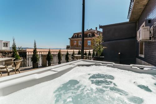 uma banheira de hidromassagem no telhado de uma casa em Royal Collection Covilh na Covilh