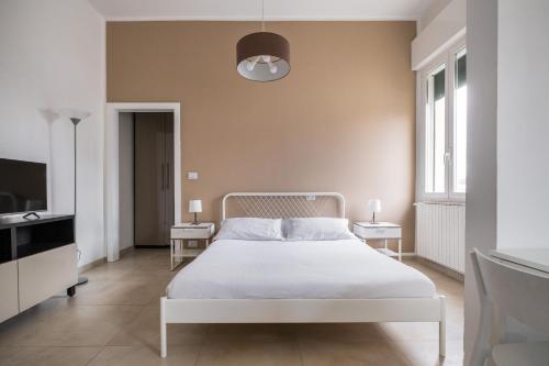 1 dormitorio con 1 cama blanca y TV en Palazzina Carracci en Bolonia