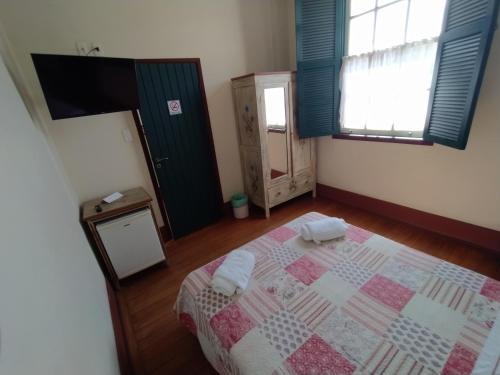 a bedroom with a bed with two towels on it at Pousada do Duque in Lambari