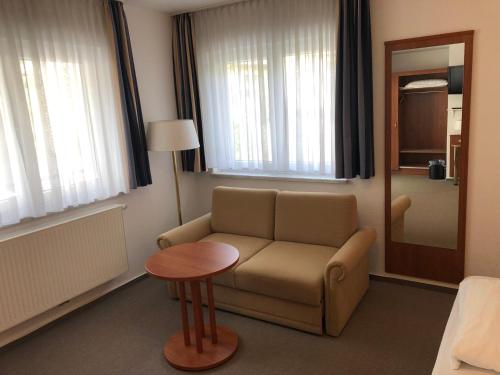 a living room with a couch and a table at Hotel Garni Rabennest in Braubach