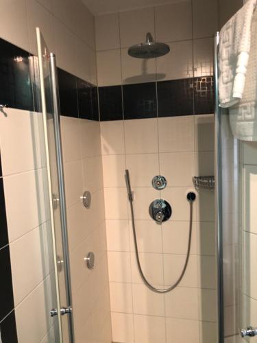 uma casa de banho com um chuveiro e uma porta de vidro em Hotel Garni Rabennest em Braubach