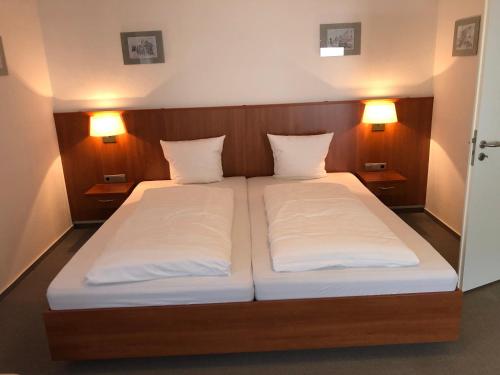 a bedroom with a bed with two white pillows at Hotel Garni Rabennest in Braubach