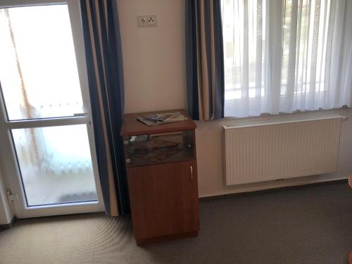 um quarto com uma pequena mesa ao lado de uma janela em Hotel Garni Rabennest em Braubach