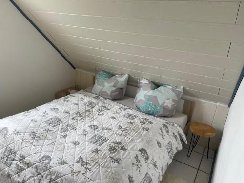 a bedroom with a bed with a comforter and pillows at Familie Decker-Behrends in Upleward