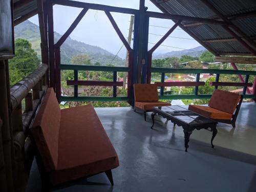 a room with two chairs and a table on a balcony at Casa de Campo La Prosperidad in Bobadilla