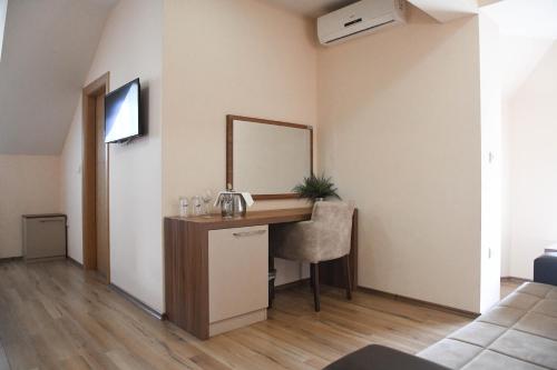 a room with a vanity with a mirror and a sink at Hotel Garden in Novi Sad