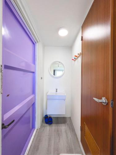 a bathroom with a purple door and a sink at SHOW Liquiu B&B in Xiaoliuqiu