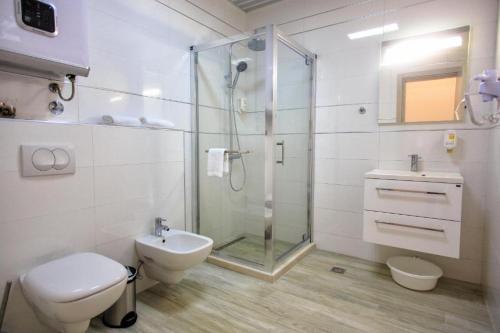 uma casa de banho com um chuveiro, um WC e um lavatório. em Nautilus Apartments em Dobra Voda