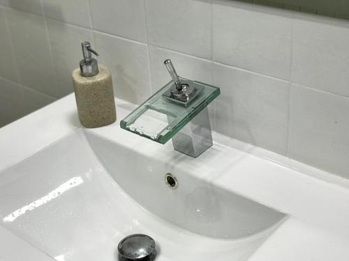 a bathroom sink with a soap dispenser on top of it at Piso céntrico con Parking a 20min de Barcelona in Terrassa