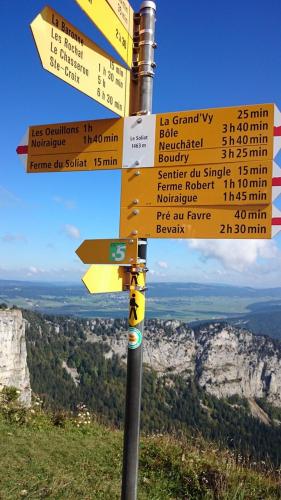 a street sign on top of a mountain at Halte au pied du Creux du Van in Travers