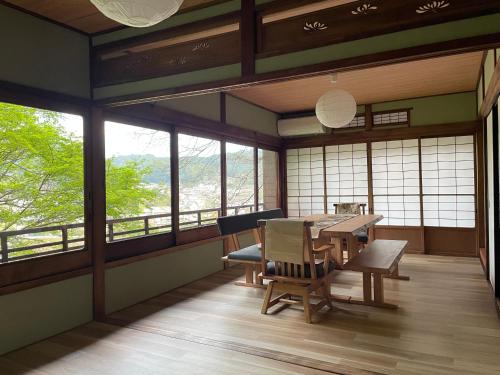 - une salle à manger avec une table, des chaises et des fenêtres dans l'établissement えん吉野絶景広がる隠れ家1棟貸切ペットokサウナ室完備, à Yoshino