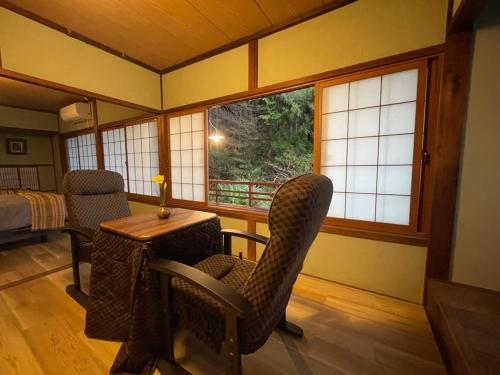 a room with a table and chairs and a window at えん吉野絶景広がる隠れ家1棟貸切ペットokサウナ室完備 in Yoshino
