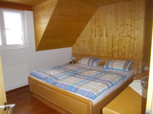 a bedroom with a bed with a wooden wall at Ferienwohnung Zweilinden in Steinen