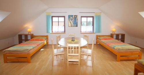 a room with two beds and a table and chairs at Apartmán V sadu in Míšov