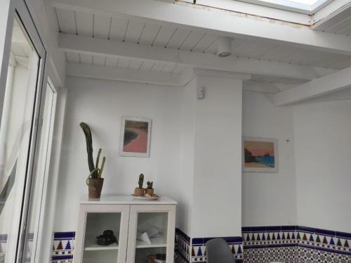 a room with a white wall and a shelf with plants at Laylas Beach Art House in Cotillo