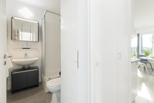 a white bathroom with a toilet and a sink at Haus Seebad Aussicht in Grömitz