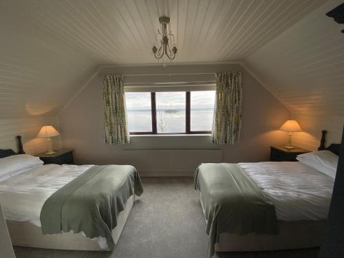 a bedroom with two beds and a window at Tullybay Holiday Homes in Tully