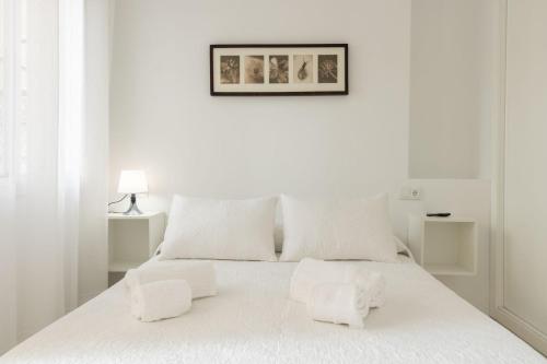 Dormitorio blanco con cama blanca y almohadas blancas en Bordador Central Courtyard by Valcambre, en Sevilla