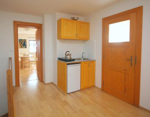 an empty kitchen with a sink and a door at Apartmán V sadu in Míšov