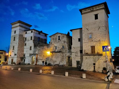 un vecchio edificio in pietra con due torri di notte di Torre degli Arduini, San Giacomo, Spoleto a San Giacomo