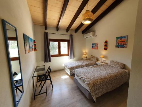 une chambre avec deux lits et une table et des chaises dans l'établissement Villa Lara, à Sa Pobla