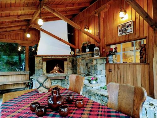 德里亞諾沃的住宿－Villa Dryanovo，一间带桌子和石头壁炉的用餐室